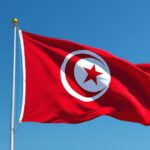 Drapeau tunisien rouge avec croissant et étoile flottant dans le ciel